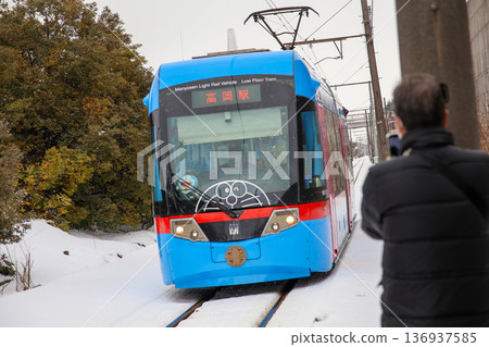 Manyo Line light rail running through a snowy landscape Manyo Line light rail running through a snowy landscape 136937585