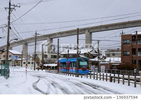 Manyo Line light rail running through a snowy landscape Manyo Line light rail running through a snowy landscape 136937594