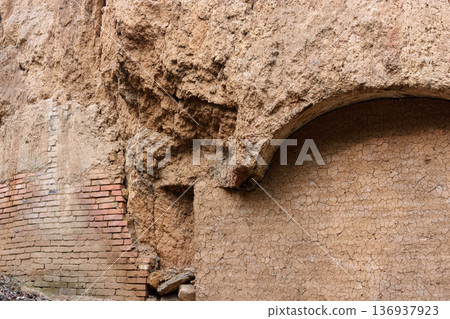 Weathered adobe ruin wall with brick arch detail Weathered adobe ruin wall with brick arch detail 136937923