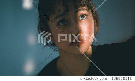 Young woman looking towards the light Young woman looking towards the light 136938118