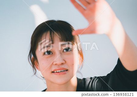 微笑的女子用手擋住陽光。 136938121