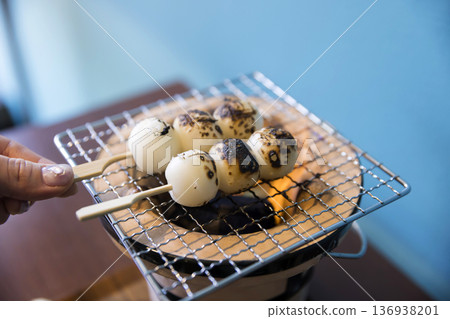 一位婦女在炭火烤架上烤餃子 136938201