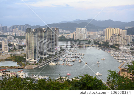 Aerial view of the Sanya city, Hainan, China, the marina with yachts and the mountains 136938384