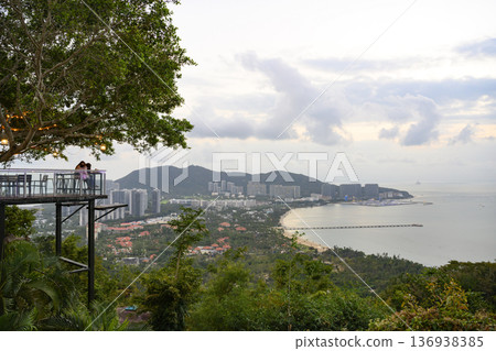 View of the sea bay from the tropical park on mountain in evening in Sanya, Hainan, China 136938385