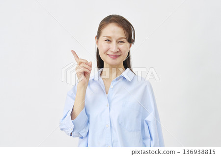 Woman pointing to the left on a white background 136938815