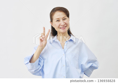 A woman making a peace sign on a white background A woman making a peace sign on a white background 136938828