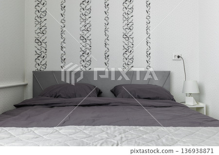Modern Bedroom Interior Detail with Grey Bed and Patterned Wallpaper Modern Bedroom Interior Detail with Grey Bed and Patterned Wallpaper 136938871