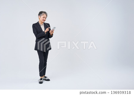 Senior woman operating a smartphone Senior woman operating a smartphone 136939318