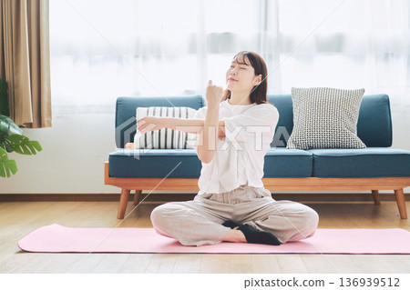 Healthy habits of a woman in her 30s stretching at home 136939512