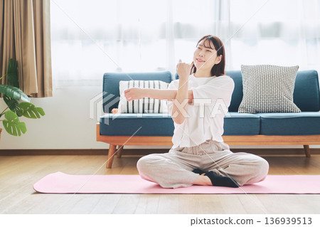 Healthy habits of a woman in her 30s stretching at home 136939513
