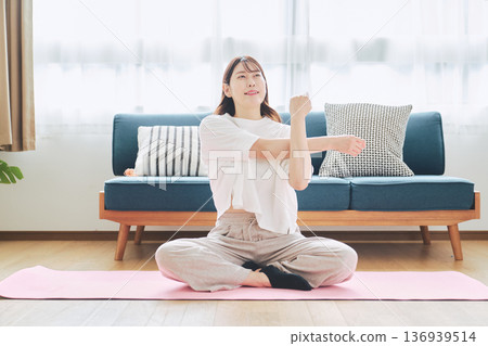 Healthy habits of a woman in her 30s stretching at home 136939514