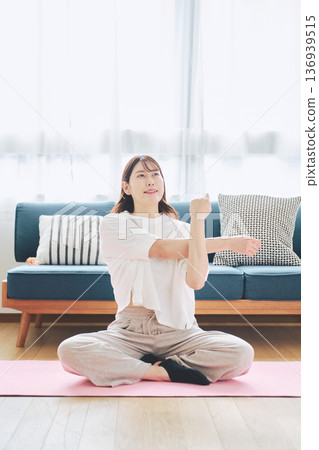 Healthy habits of a woman in her 30s stretching at home 136939515