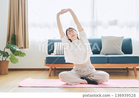 Healthy habits of a woman in her 30s stretching at home 136939528