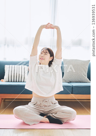 Healthy habits of a woman in her 30s stretching at home 136939531