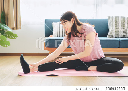 Healthy habits of a woman in her 30s stretching at home 136939535