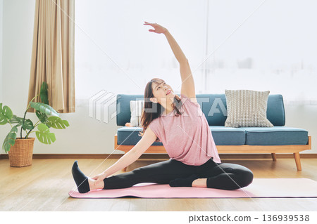 Fitness life of a woman in her 30s doing yoga poses in her living room 136939538