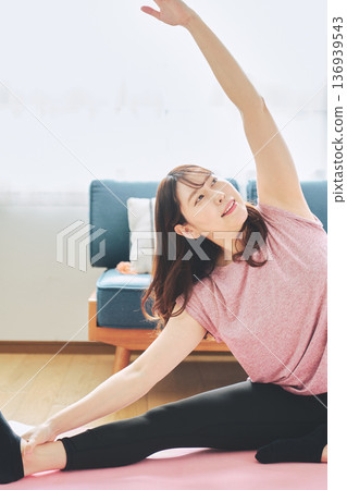 Fitness life of a woman in her 30s doing yoga poses in her living room 136939543