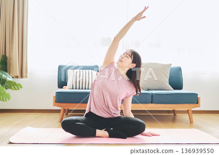 Fitness life of a woman in her 30s doing yoga poses in her living room Fitness life of a woman in her 30s doing yoga poses in her living room 136939550
