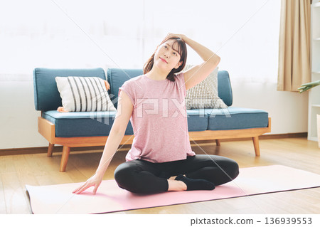 Healthy habits of a woman in her 30s stretching at home 136939553