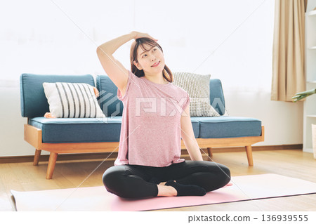 Healthy habits of a woman in her 30s stretching at home 136939555