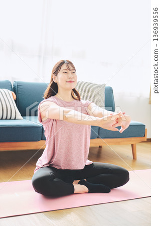 Healthy habits of a woman in her 30s stretching at home 136939556