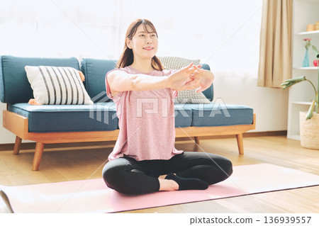 一位30多歲女性在家做伸展運動的健康習慣 136939557
