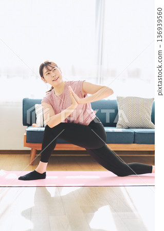 一位30多歲的女性在客廳做瑜伽，展現她的健身生活 136939560