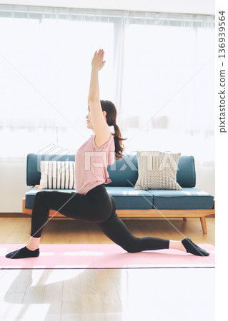 Fitness life of a woman in her 30s doing yoga poses in her living room 136939564