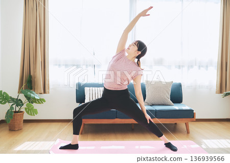 Fitness life of a woman in her 30s doing yoga poses in her living room 136939566