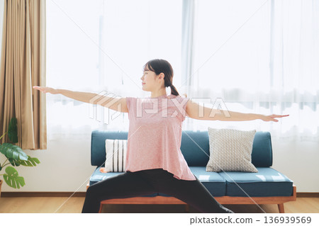 Fitness life of a woman in her 30s doing yoga poses in her living room Fitness life of a woman in her 30s doing yoga poses in her living room 136939569