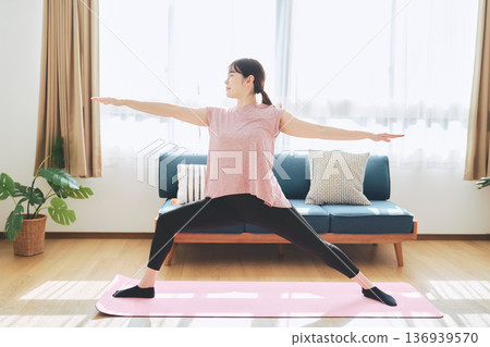 Fitness life of a woman in her 30s doing yoga poses in her living room 136939570