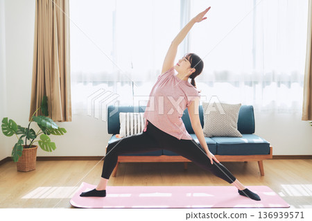 Fitness life of a woman in her 30s doing yoga poses in her living room Fitness life of a woman in her 30s doing yoga poses in her living room 136939571