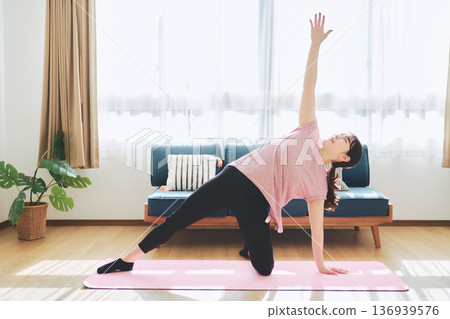 Fitness life of a woman in her 30s doing yoga poses in her living room Fitness life of a woman in her 30s doing yoga poses in her living room 136939576