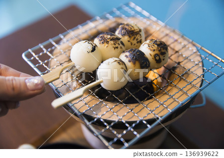 一位婦女在炭火烤架上烤餃子 136939622