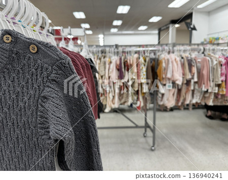Clothing rack in modern retail store with sweaters and hangers 136940241