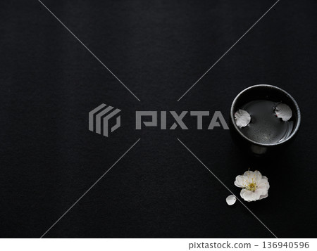 黑色背景上的梅花和清酒杯-日式春季設計,留白充足。 黑色背景上的梅花和清酒杯-日式春季設計,留白充足。 136940596