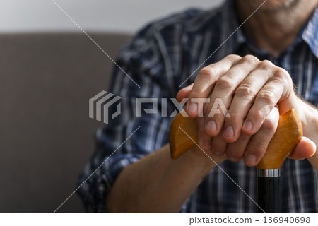 Middle age caucasian man hands holds cane closeup 136940698