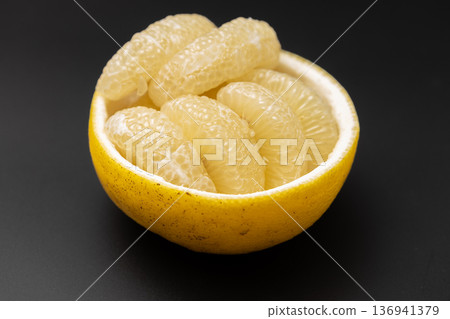 Stock photo of sour pomelo: A cute arrangement of large citrus fruits peeled and arranged on the skin 136941379