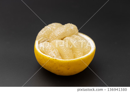 Stock photo of sour pomelo: A cute arrangement of large citrus fruits peeled and arranged on the skin 136941380