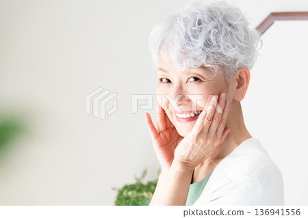 Senior woman feeling the moisture in her skin Senior woman feeling the moisture in her skin 136941556