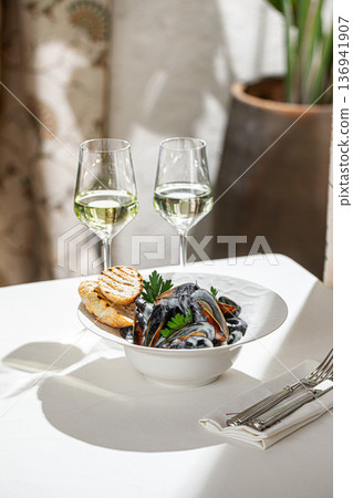 Steamed mussels with bread and white wine 136941907