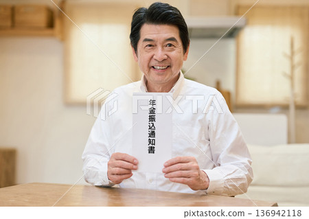 一位微笑的亞裔老年男子手持退休金轉移通知書 136942118