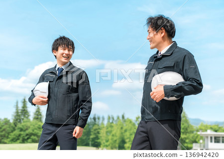 身穿工作服的男工人在工地行走（建築業、交通運輸業、土木工程業、總承包商） 136942420