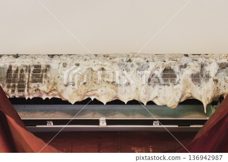 Close up of dirty air conditioner cooling coil covered with foam cleaner during maintenance. Close up of dirty air conditioner cooling coil covered with foam cleaner during maintenance. 136942987