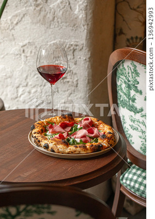 Prosciutto pizza with arugula and red wine Prosciutto pizza with arugula and red wine 136942993