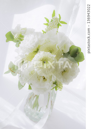 A bouquet of white flowers placed on a sunny windowsill, vertical position A bouquet of white flowers placed on a sunny windowsill, vertical position 136943022