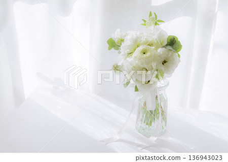 一束白色鮮花擺放在陽光明媚的窗台上。 一束白色鮮花擺放在陽光明媚的窗台上。 136943023