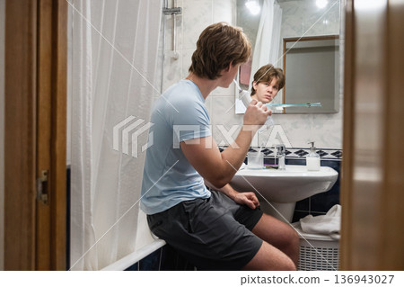Relaxed morning hygiene routine in bathroom. Brushing Teeth Relaxed morning hygiene routine in bathroom. Brushing Teeth 136943027