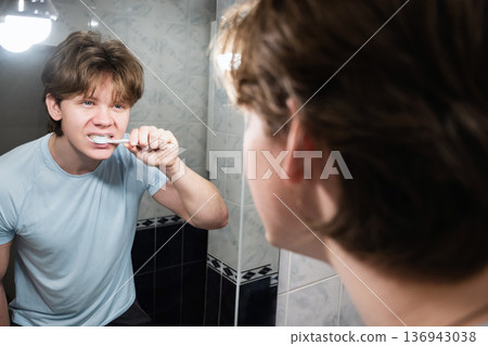 Brushing teeth in front of bathroom mirror. Brushing Teeth Brushing teeth in front of bathroom mirror. Brushing Teeth 136943038