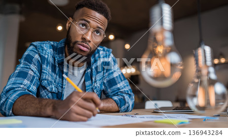 Young man beard casual shirt office thinking writing desk lightbulb workspace creative young man with beard casual shirt office desk thinking 136943284
